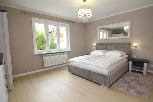 a bedroom with a bed and a mirror and a chandelier at Apartamenty Świnoujście - Słowackiego in Świnoujście