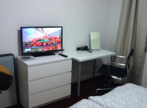 1 dormitorio con escritorio y TV. en ask rooms Privatzimmer in Kassel en Kassel