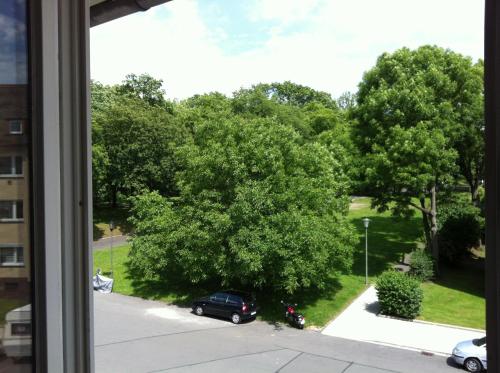 una ventana con vistas a una calle con un árbol en ask rooms Privatzimmer in Kassel en Kassel
