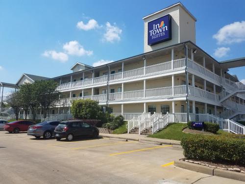 a hotel with cars parked in a parking lot at InTown Suites Extended Stay Houston TX - Greenspoint in Houston
