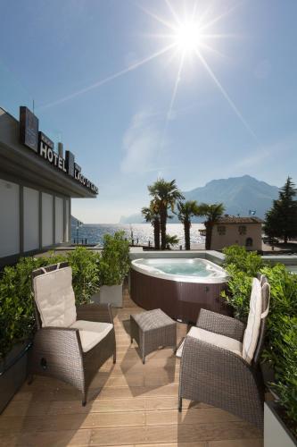 a patio with chairs and a hot tub on top of a hotel at Hotel Lago Di Garda in Nago-Torbole