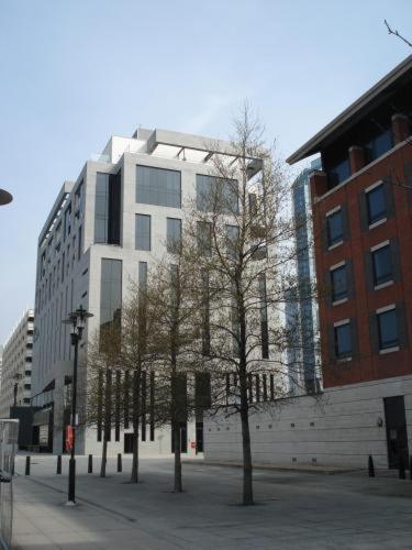 a tall white building with trees in front of it at Merchant Quarters Apartments in Liverpool