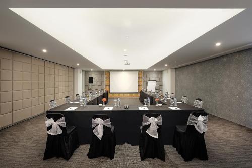 a conference room with a table with bows on it at Jambuluwuk Oceano Seminyak Hotel in Seminyak