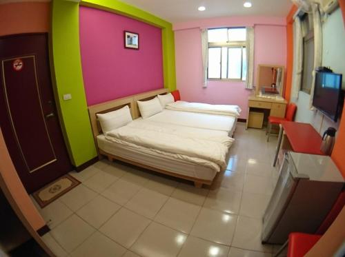 a small room with two beds and a television at ZaiXiang in Tamsui