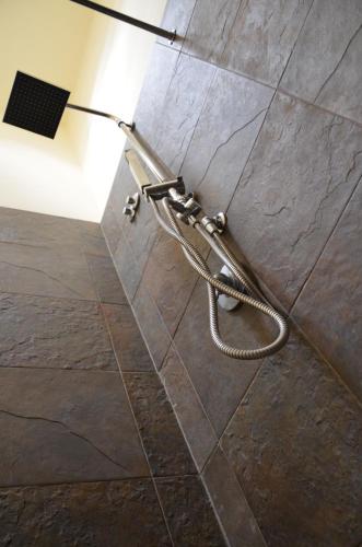 a shower nozzle in a bathroom with a tiled floor at B&B Chapo in Catania