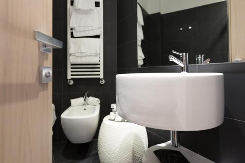 a bathroom with a white sink and a toilet at Hotel Lago Di Garda in Nago-Torbole