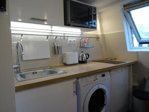 uma cozinha com um lavatório e uma máquina de lavar roupa em Cosy Studio near Champs-Elysées - Arc de Triomphe em Paris