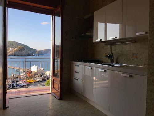 a kitchen with a view of the water and a balcony at Porto di Ponza - Immobilevante in Ponza