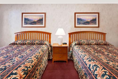 a hotel room with two beds and a table with a lamp at Super 8 by Wyndham Traverse City in Traverse City
