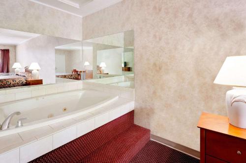 a bathroom with a large tub and a large mirror at Knights Inn Traverse City in Traverse City