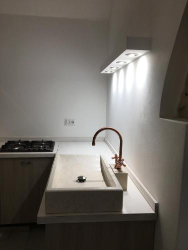 a kitchen with a sink and a stove at Mandralisca Garden in Cefalù