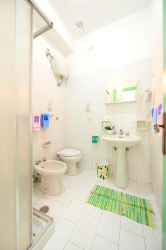 a white bathroom with a sink and a toilet at Villa Angela Apartment in Ischia Town