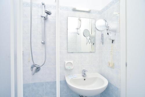 a white bathroom with a sink and a shower at Charme Hotel La Villa Tina in Ischia