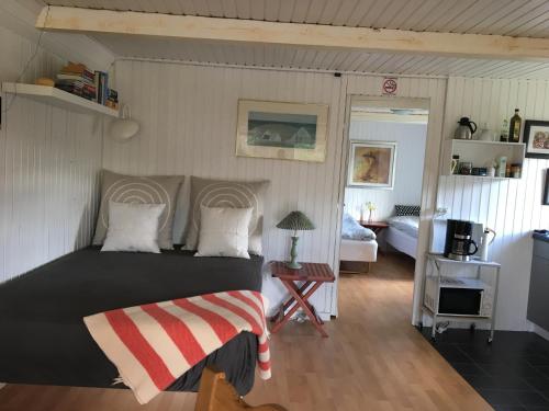 ein Schlafzimmer mit einem Bett und ein Wohnzimmer in der Unterkunft Abildskovhus Feriebolig in Funder Kirkeby