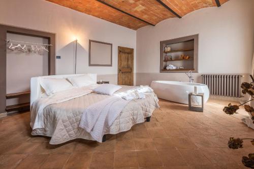 a bedroom with a large bed and a bath tub at Agriturismo Poggio Istiano in Bagno Vignoni