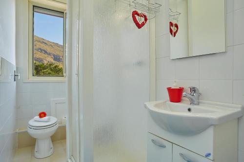 スフェッラカヴァッロにあるAppartamento Girasoleのバスルーム(洗面台、トイレ付)、窓が備わります。