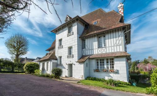 una casa blanca con techo marrón en Le Manoir du Vert Galant, en Deauville