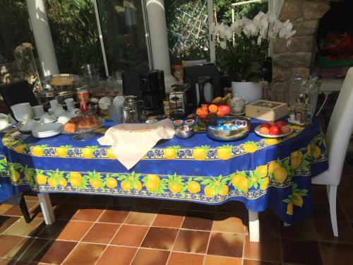 un tavolo con una tovaglia blu con del cibo sopra di Villa Manù B&B Chambre D'hote a Les Issambres