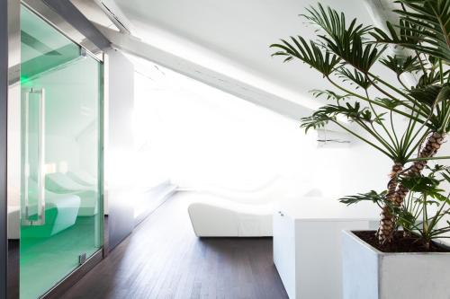 a living room with a white couch and a plant at Hotel Lago Di Garda in Nago-Torbole