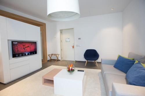 a living room with a couch and a tv at Seen Hotel Abidjan Plateau in Abidjan