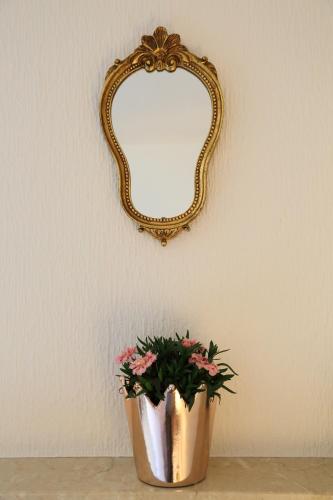 a mirror on a wall with a vase with flowers at Bio & Vegi Pension Krennleiten in Schönau am Königssee