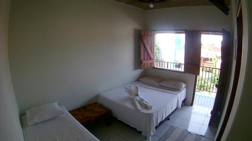 a small bedroom with a bed and a window at Pousada Segredo in Bonito