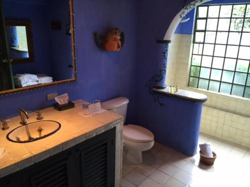 a bathroom with a sink and a toilet and a mirror at Hotel Casa Palopo in Santa Catarina Palopó