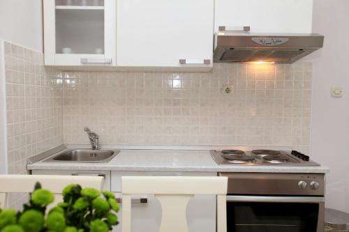 a kitchen with a sink and a stove at Hotel Bellevue Trogir in Trogir