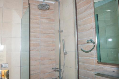 a shower with a glass door in a bathroom at Hotel Zografos in Paralia Katerinis