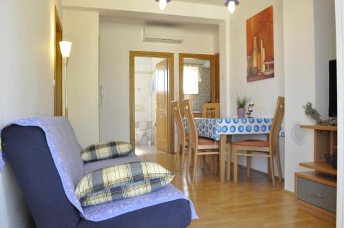 a living room with a blue couch and a table at Apartments Zecevic in Vrh