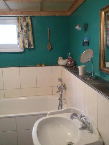 a bathroom with a sink and a bath tub at Romantikmühle Heartlandranch in Krummenau