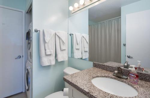 a bathroom with a sink and a toilet and a mirror at Signature Suites 11 in Honolulu