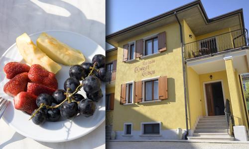 a plate of fruit and grapes and a building at Relais Sweet Days in Peschiera del Garda