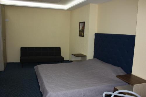 ドニプロにあるSolnechny hotelのベッドとソファ付きのホテルルーム