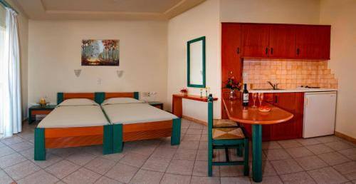 a bedroom with a bed and a table and a kitchen at Papadakis in Georgioupolis