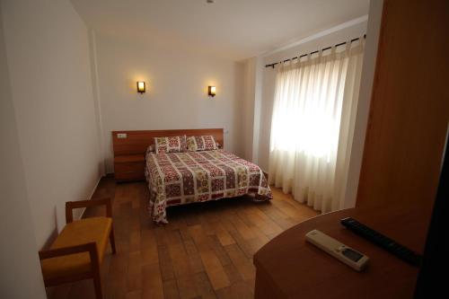 a small bedroom with a bed and a window at Hostal Nueva Tabarca in Tabarca