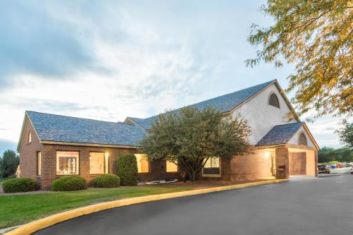 a brick house with a gambrel roof at Super 8 by Wyndham Dodgeville in Dodgeville