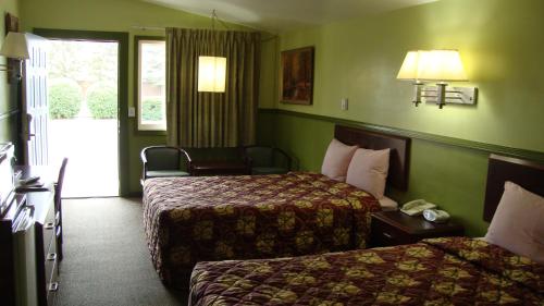 Säng eller sängar i ett rum på Pinconning Trail Inn Motel