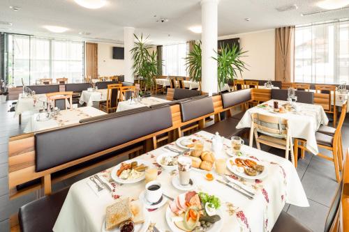 ランツフートにあるHotel Bettstadlの食卓付きレストラン