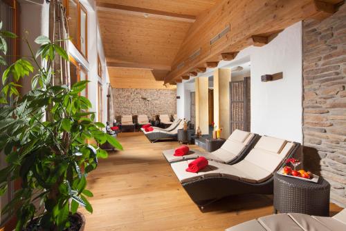 a living room with couches and a brick wall at Hotel Hindenburglinde in Ramsau
