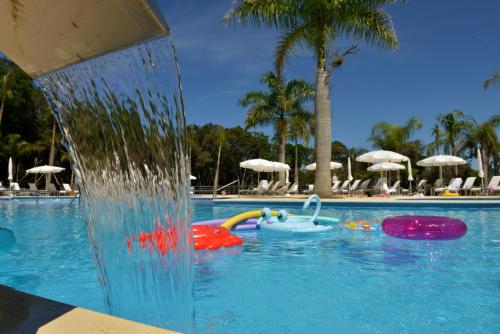 a pool with a water fountain in a resort at Falls Iguazú Hotel & Spa in Puerto Iguazú