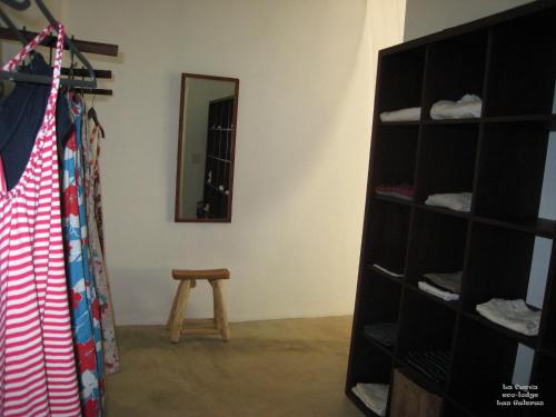 a room with a closet with a mirror and a stool at La Cueva Eco-Lodge in Las Galeras