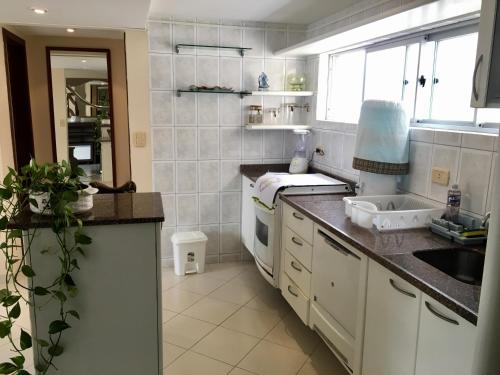 a kitchen with a sink and a counter top at Linda Cobertura Caiobá, amplo terraço com churrasqueira, e linda vista na Av Atlântica, Edificio Frente Mar in Caiobá