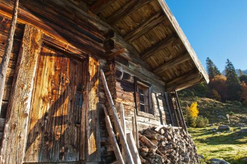 una antigua cabaña de madera con puerta de madera en Roana-Krumma, en Scheffau am Wilden Kaiser