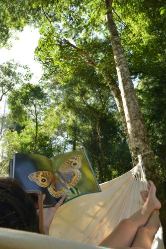 a person laying in a hammock with a butterfly umbrella at Falls Iguazú Hotel & Spa in Puerto Iguazú