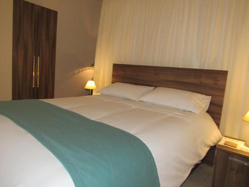 a bedroom with a large white bed with a wooden headboard at Central Studio Apartment in Santa Venera
