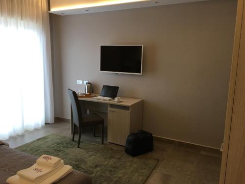 a hotel room with a desk with a laptop and a television at Alludo Aparthotel b&b in Agrigento