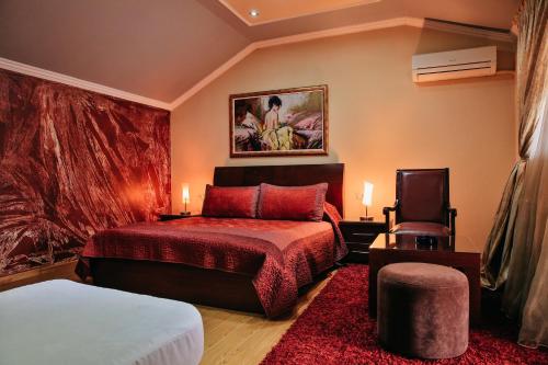 een hotelkamer met een bed en een stoel bij Gold Hotel in Korçë