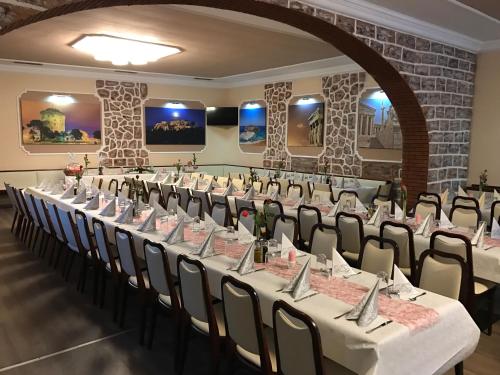 a row of tables and chairs in a room at Hotel Korfu in Geiselhöring