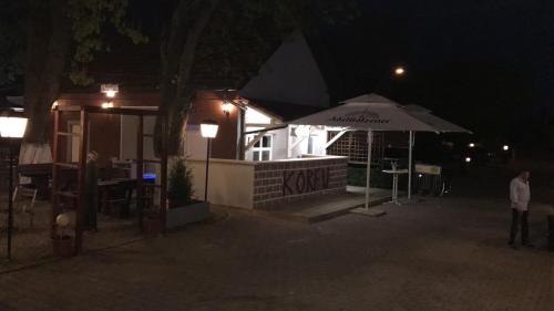 a restaurant at night with an umbrella in front of it at Hotel Korfu in Geiselhöring